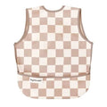 Babete de bebé impermeável da Tiny Twinkle com padrão de quadrados bege e branco, sem mangas e com bolso frontal.