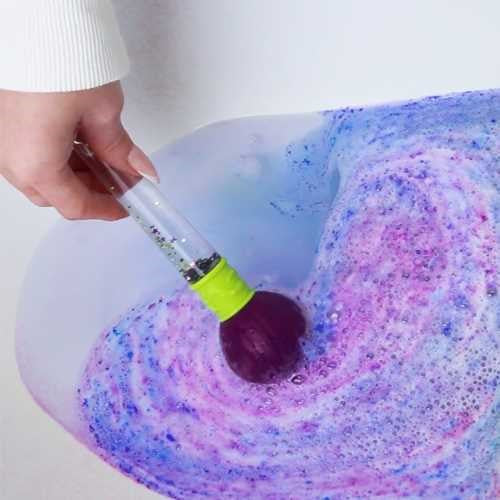 Pincel Mágico Zimpli Kids a misturar cores roxas e azuis na água do banho, criando um efeito artístico e efervescente.