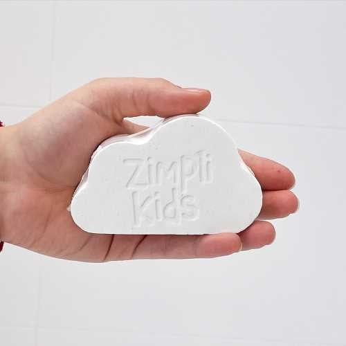 Mão a segurar a bomba de banho Zimpli Kids em forma de nuvem com o logótipo visível.