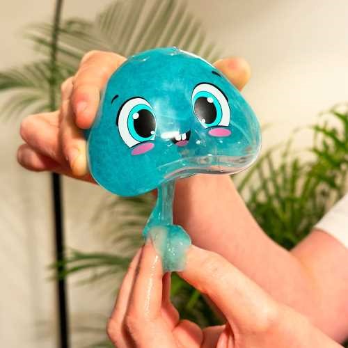 Mãos a manipular o slime azul brilhante dentro da medusa ZIMPLIKIDS Glowy, mostrando a textura maleável.