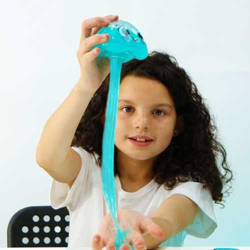 Criança sorridente a segurar a medusa ZIMPLIKIDS Glowy com o slime azul a escorrer, demonstrando o comprimento e a diversão.