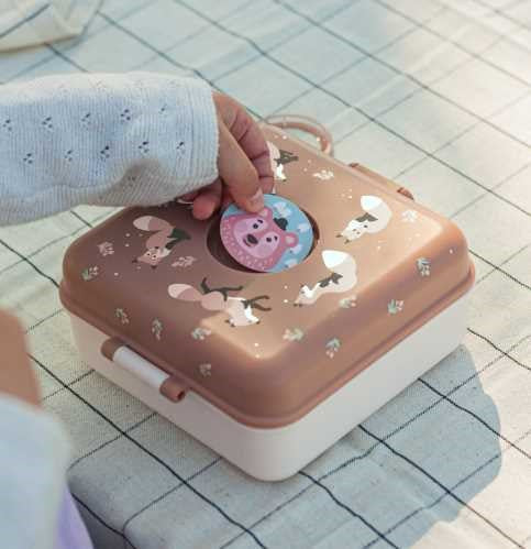 Criança a personalizar a tampa da sua lancheira Monbento Snacky Raposa com um dos autocolantes de animais incluídos.