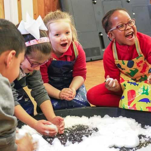 Crianças felizes a brincar com as ZIMPLIKIDS Bolas de Neve, explorando a textura sensorial da neve artificial.