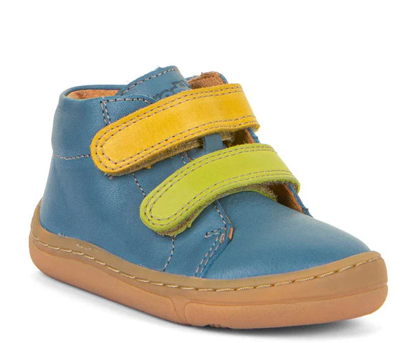 Bota barefoot infantil em couro azul com sola flexível em borracha térmica. Fecho com duas tiras de velcro amarelas e verdes. Modelo confortável e sustentável.