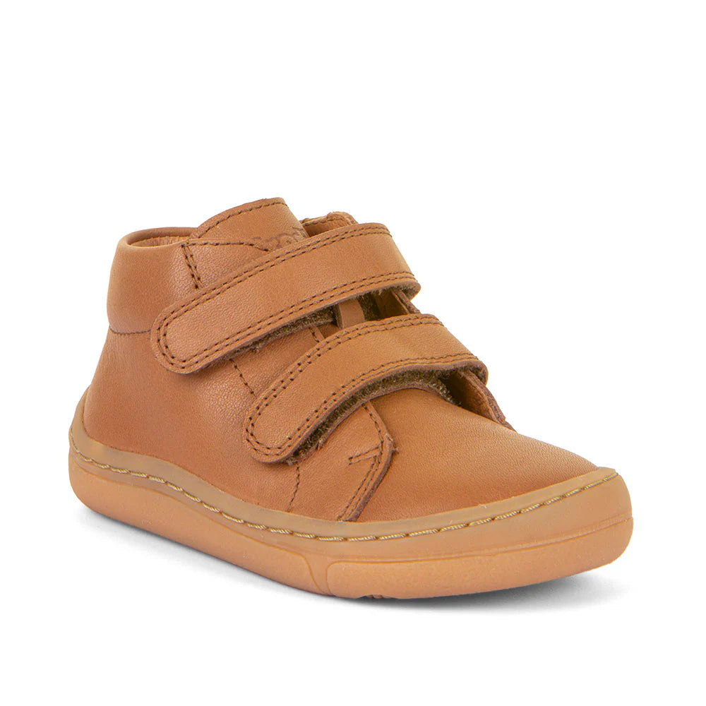 Bota barefoot infantil em couro cognac resistente à água, com sola flexível, fecho em velcro e palmilha antibacteriana removível. Sustentável e confortável.

