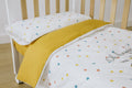 Conjunto de protetor e edredom Micuna Happy 120x60 para berço, com lado reversível amarelo e padrão de confetis coloridos.