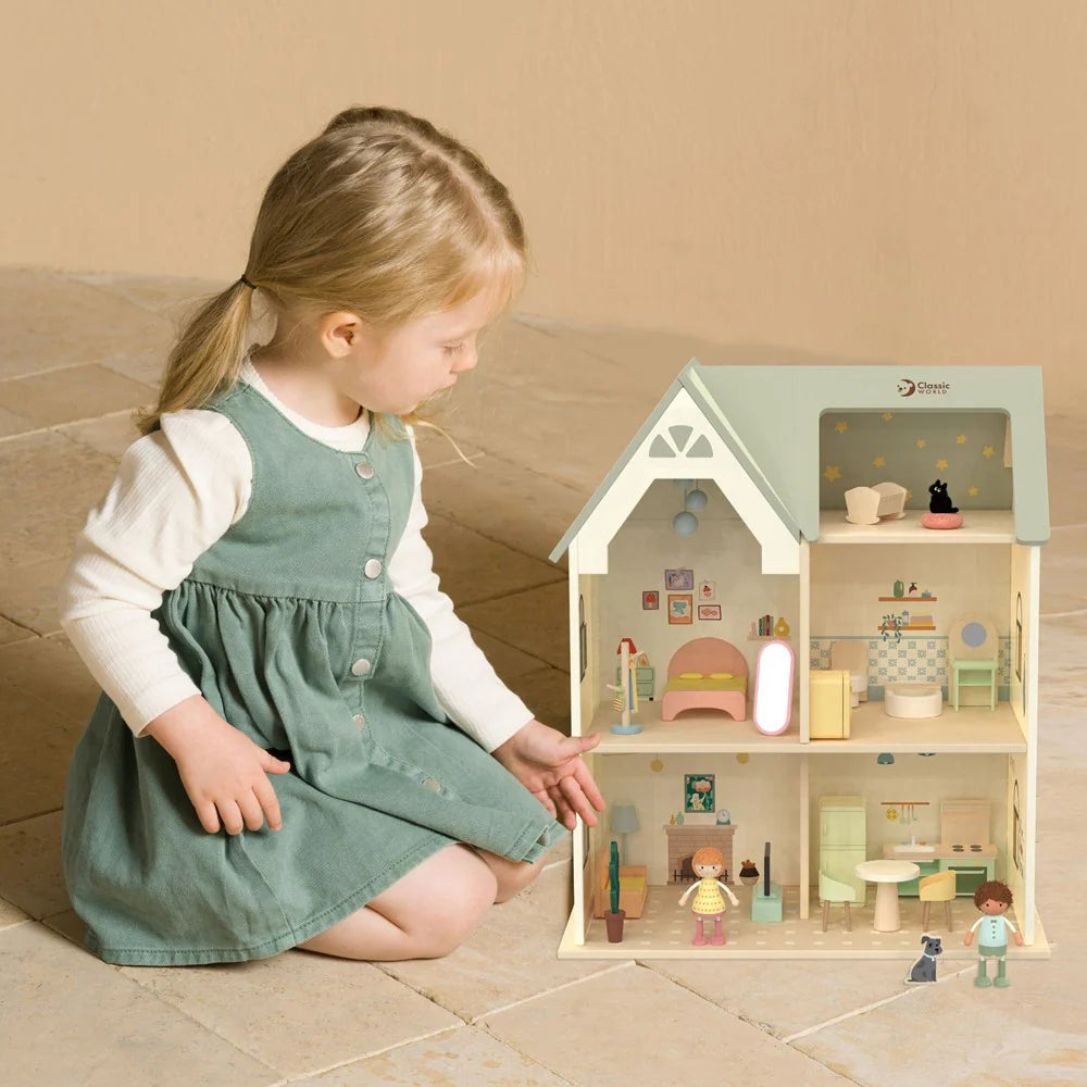 Criança a brincar com a Classic World Casa de Campo para bonecas de madeira, exibindo o interior mobilado e figuras.