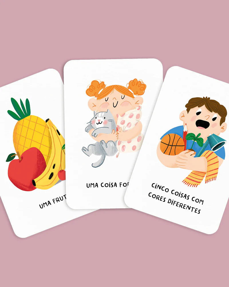 Três cartas do jogo The Happy Gang Procura e Encontra Em Casa, com desafios como 'Uma Fruta', 'Uma Coisa Fofa' e 'Cinco Coisas com Cores Diferentes', ilustradas.