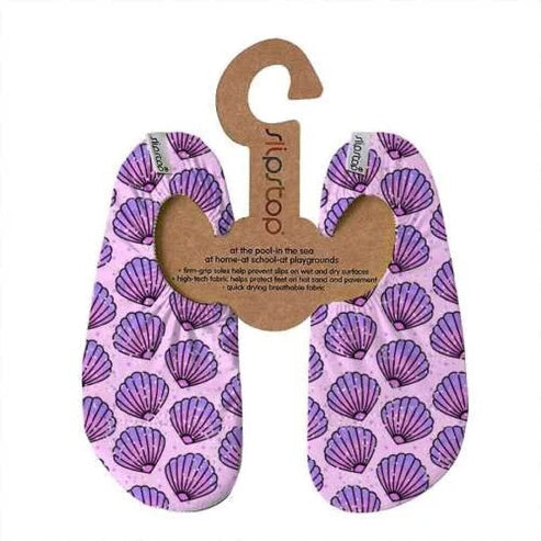 Par de meias antiderrapantes Slipstop modelo "Chacha", em tom lilás com estampado de conchas do mar em roxo. Fabricadas com tecido respirável e de secagem rápida, possuem solas antiderrapantes para maior segurança em superfícies molhadas e secas. Ideais para piscina, praia, casa ou parques infantis.