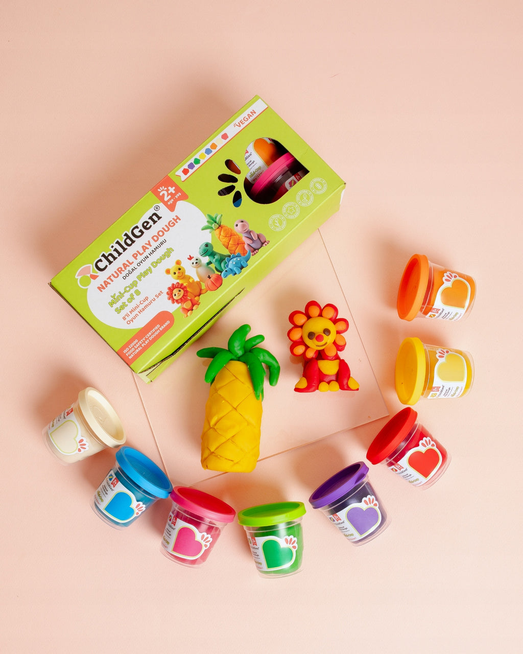 Detalhe da ChildGen Pasta de Modelar natural e suave, mostrando figuras moldadas (ananás, leão) e os oito potes de cores vivas.