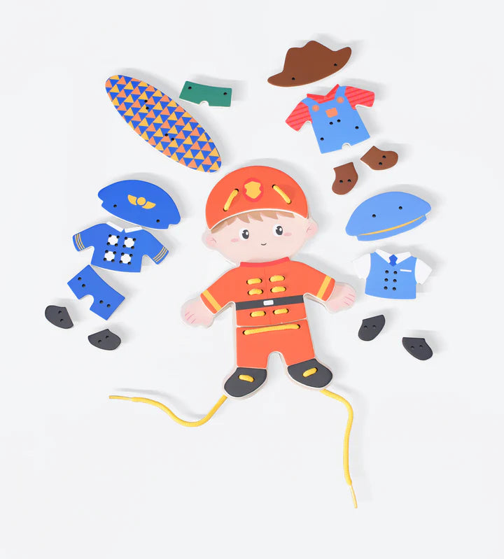Criança sorridente a brincar com o Classic World Conjunto de figuras para enlaçar - Menino, segurando a figura principal com um dos trajes.