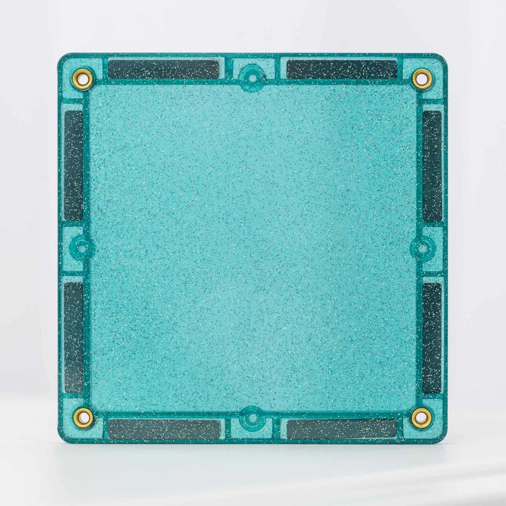 Detalhe de uma peça quadrada magnética Connetix com glitter azul-turquesa, mostrando os ímans e o design.