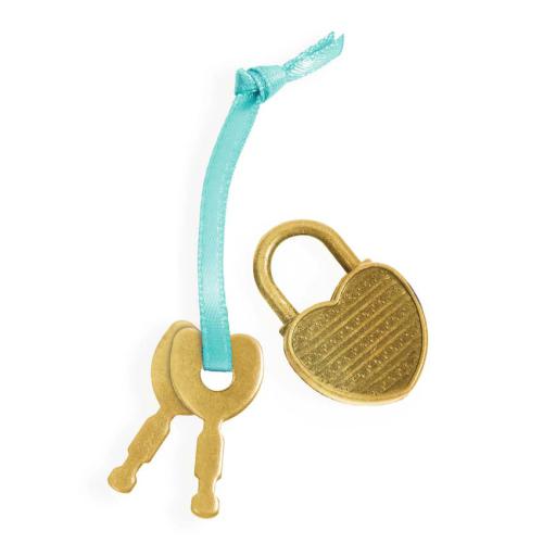 Detalhe do cadeado dourado em forma de coração e as duas chaves presas por uma fita azul, pertencentes ao diário Djeco Tinyly Prunelle.