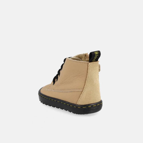 Bota Blanditos by Crio's Doha Arena em tom areia, mostrando a parte traseira e o detalhe lateral em camurça, com a marca na presilha.