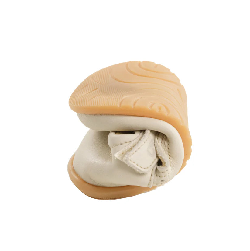Um sapato Bunny Barefoot Pantera Creme dobrado ao meio, demonstrando a sua excecional flexibilidade e maleabilidade da sola.