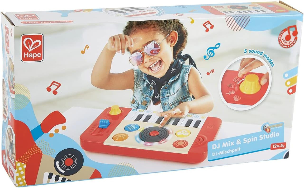 Criança sorridente com óculos de sol a interagir com a caixa do Hape Estúdio de DJ e mesa de mistura, destacando funcionalidades.