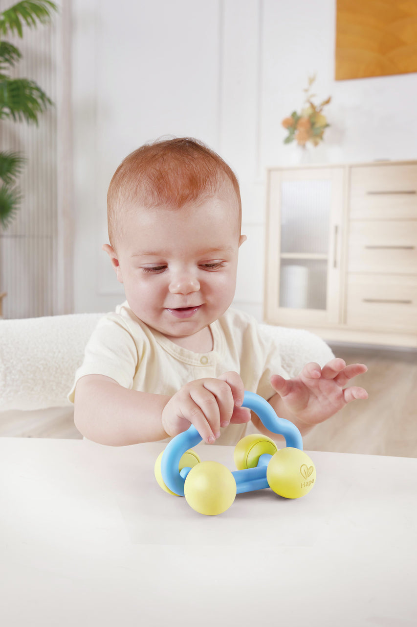 Carrinho chocalho Hape Rattle and Roll em material de arroz, leve e de toque suave para bebés