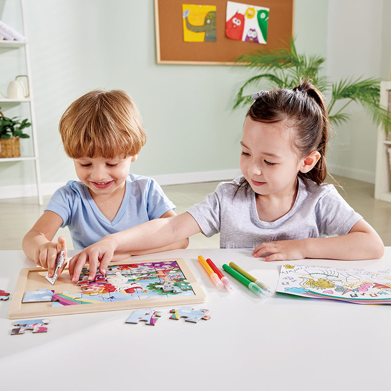 Duas crianças felizes a brincar com o Hape Puzzle de madeira Unicórnio 2 em 1, montando a imagem colorida.