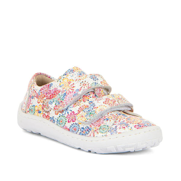 Sapatilha barefoot infantil em couro branco com padrão floral colorido. Fecho em velcro duplo para ajuste fácil, sola flexível antiderrapante e design ergonómico para conforto e liberdade de movimento.