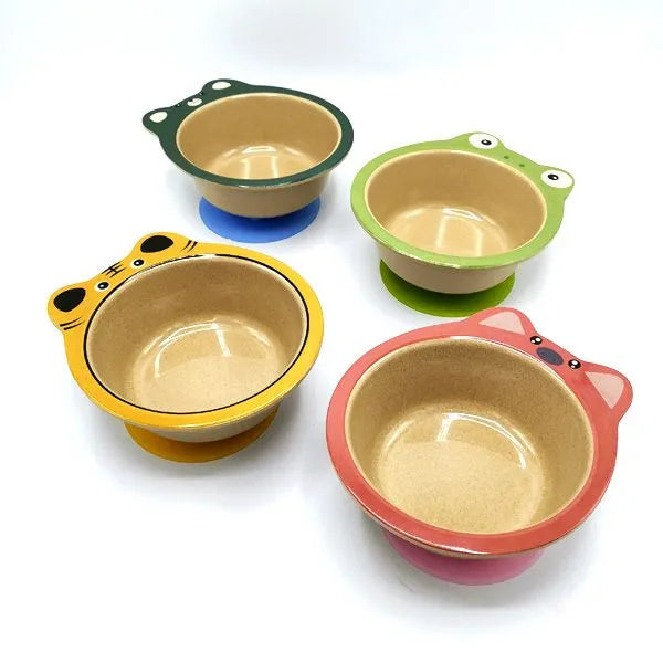 Quatro taças Husk's Baby de fibras de arroz com design de animais (porquinho, rã, tigre, urso/cão) e ventosas coloridas, vista em ângulo.