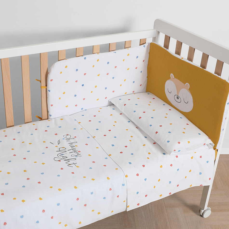 Conjunto completo Micuna Happy Protector + Edredom 120x60 num berço de madeira, com protetor de esquilo e edredom de confetis.