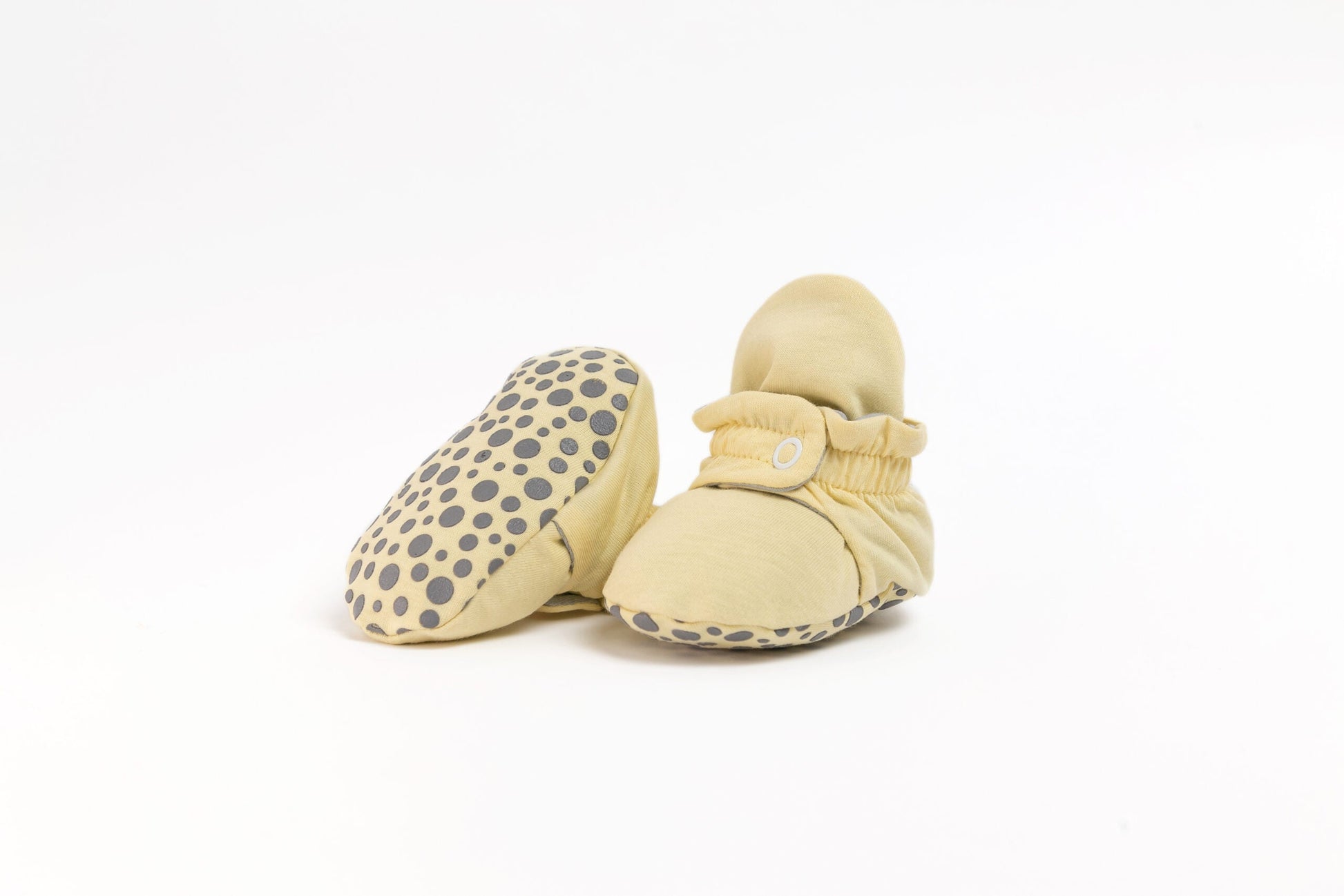 Pantufas botinhas amarelas com sola antiderrapante de padrão leopardo, destacando o conforto e a segurança para os primeiros passos do bebé.
