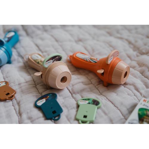 Várias lanternas projetoras KidyWolf KIDYSLIDE em diferentes cores (laranja, bege, azul) com os seus discos de slides de histórias.