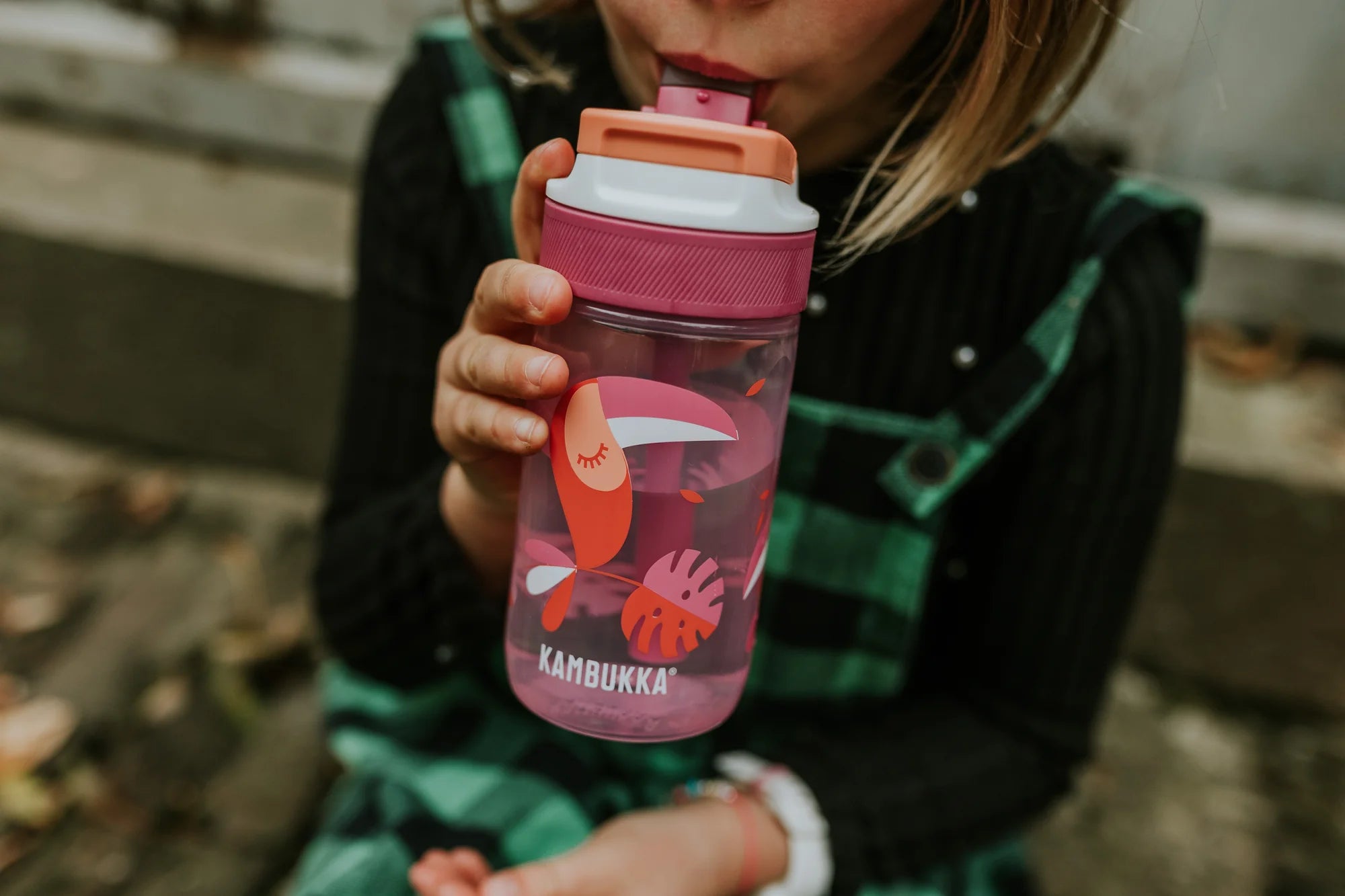 Criança a beber diretamente da garrafa Kambukka LAGOON Toekan Love 400ml, mostrando a facilidade de uso do bico.