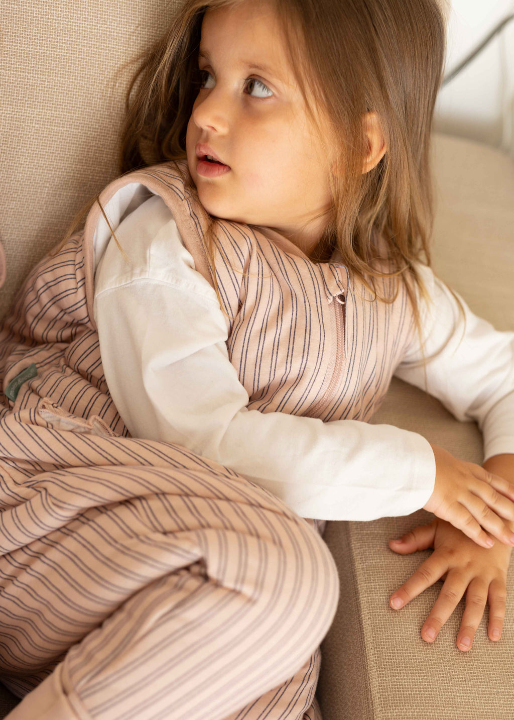 Pijama manta MolisandCo TOG 2.5 com pés e meias antiderrapantes na cor Navy and Pink Stripes, vestido por uma criança