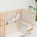 Kit nórdico e protector acolchoado Micuna Lauki em Beige, com desenho em forma de nuvem, num berço de madeira