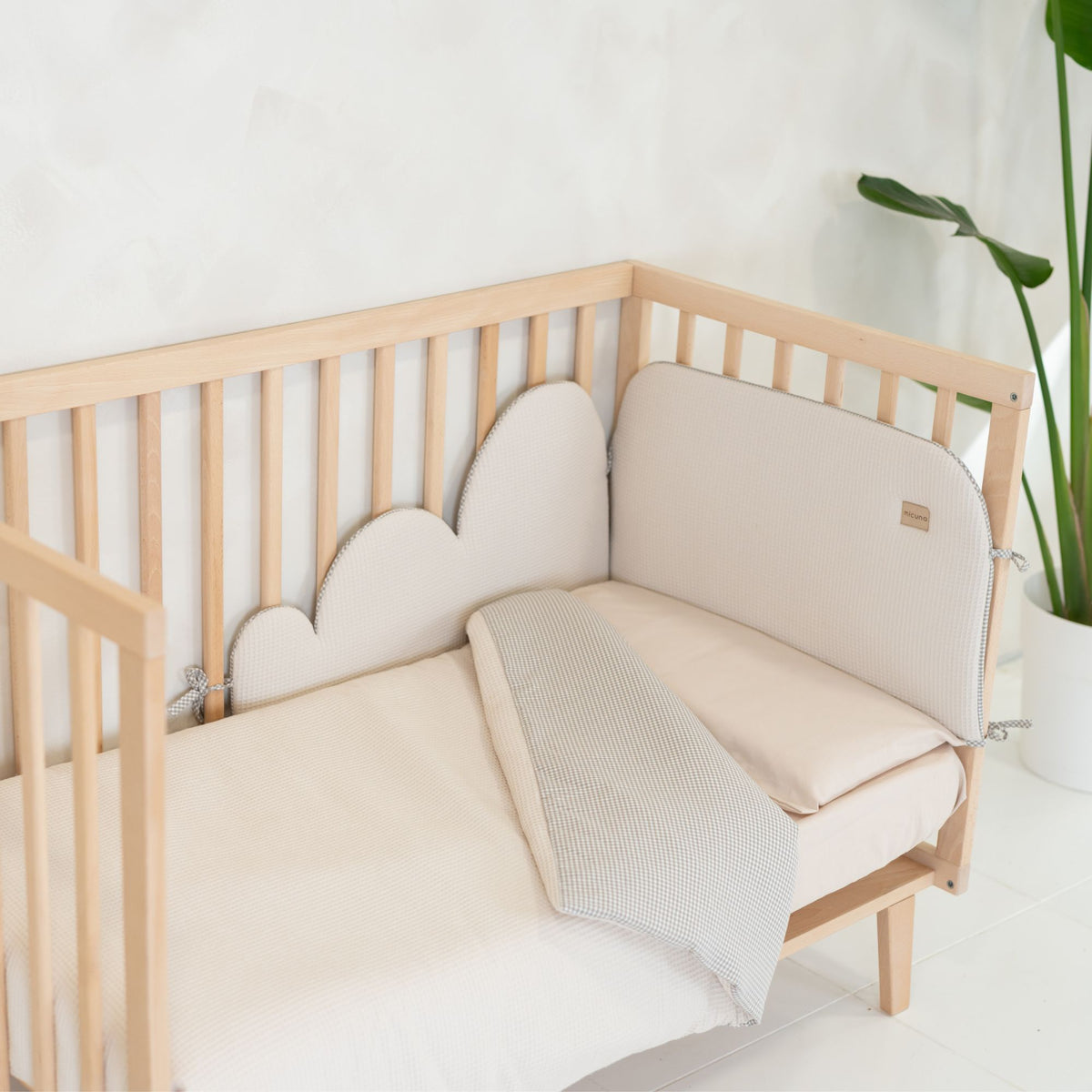 Kit nórdico e protector acolchoado Micuna Lauki em Beige, com desenho em forma de nuvem, num berço de madeira