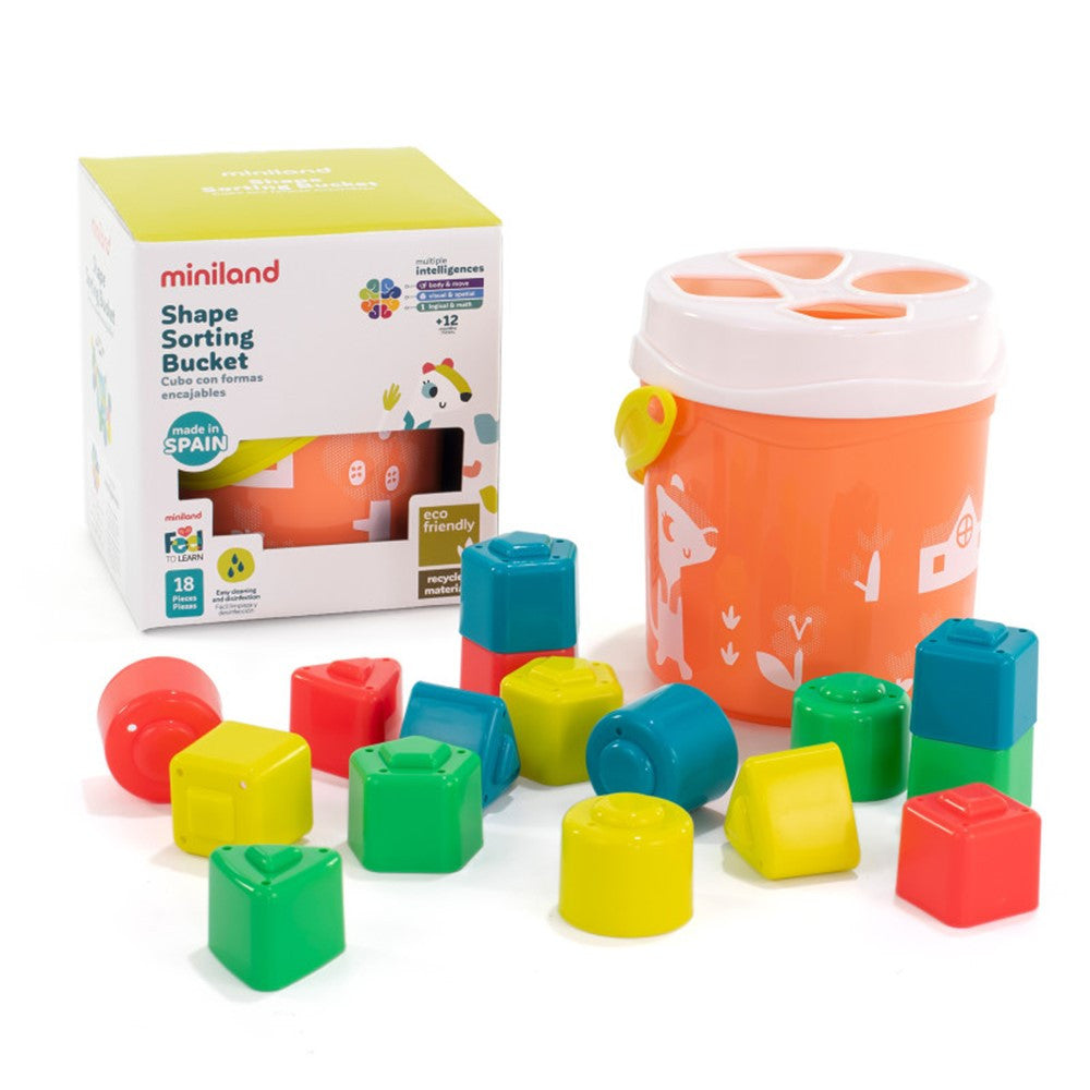 Miniland Cubo com formas de encaixe laranja, peças coloridas e a embalagem do produto, destacando as características ecológicas e a idade recomendada.