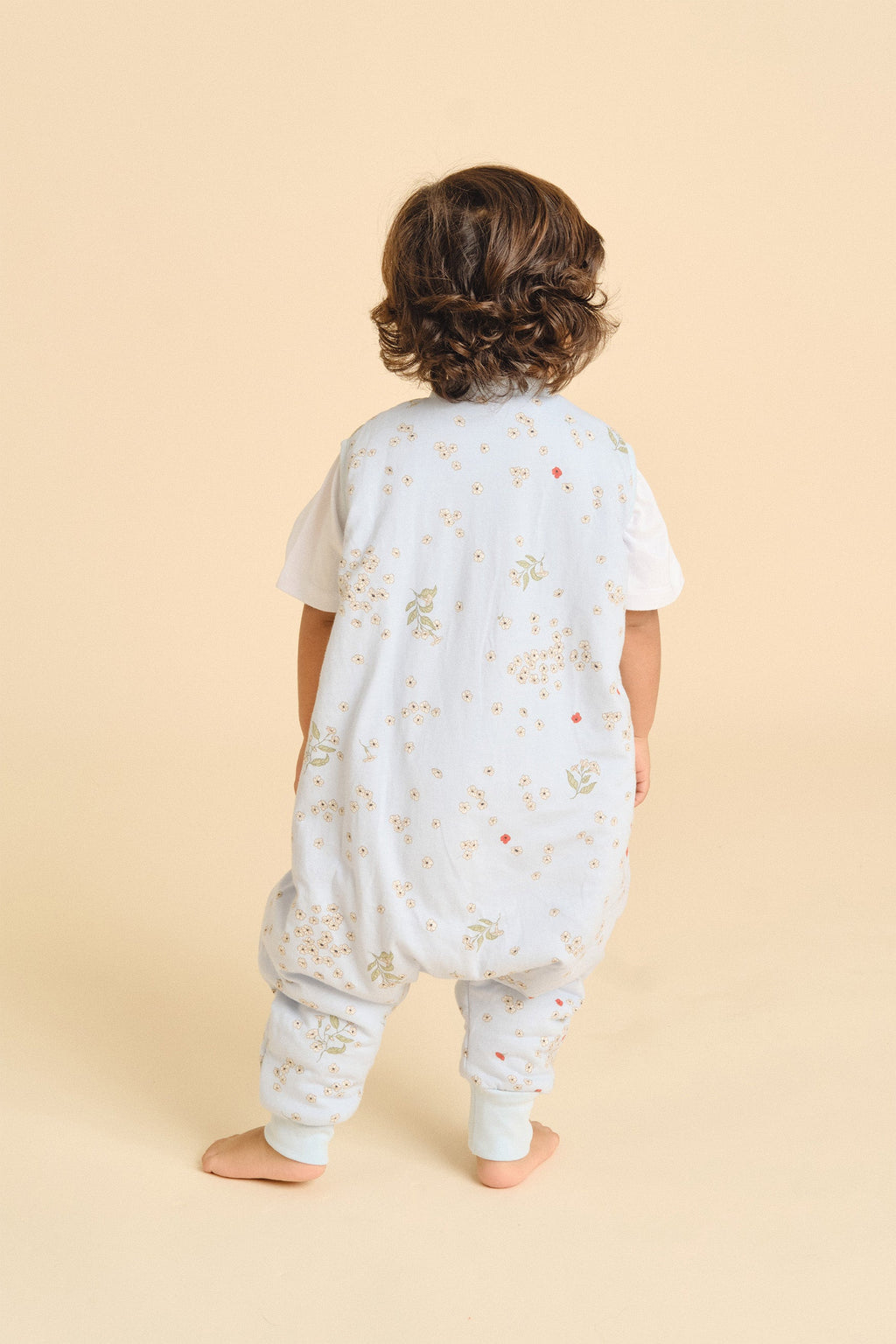 Pormenor do saco de dormir MolisandCo TOG 1.0 com pés Poppy numa criança em casa