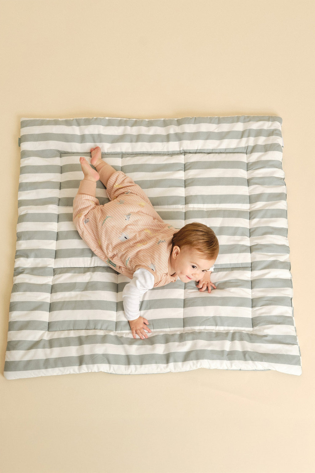 Saco de dormir MolisandCo TOG 1.0 com pés Jungle vestido sobre o pijama, em uso pela criança