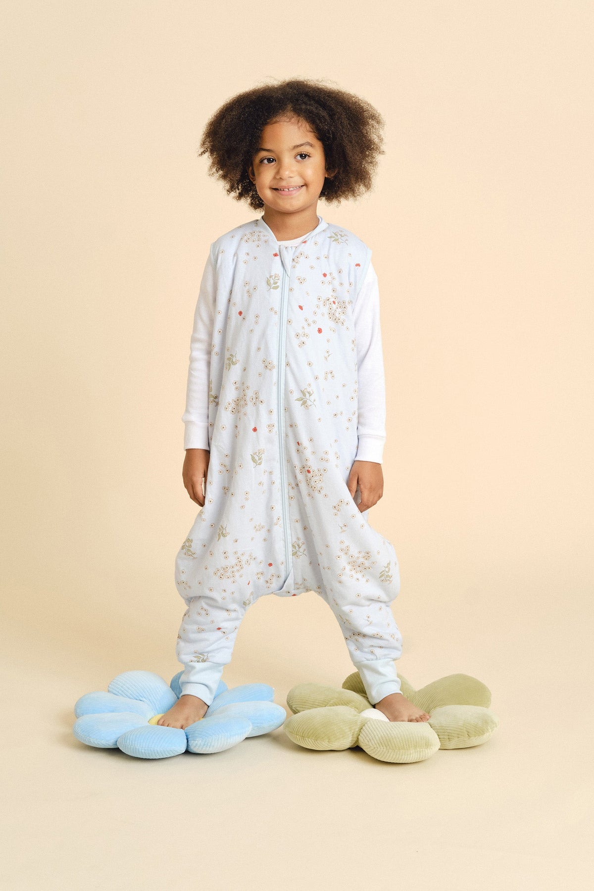 Criança vestida com o saco de dormir MolisandCo TOG 1.0 com pés no padrão Poppy