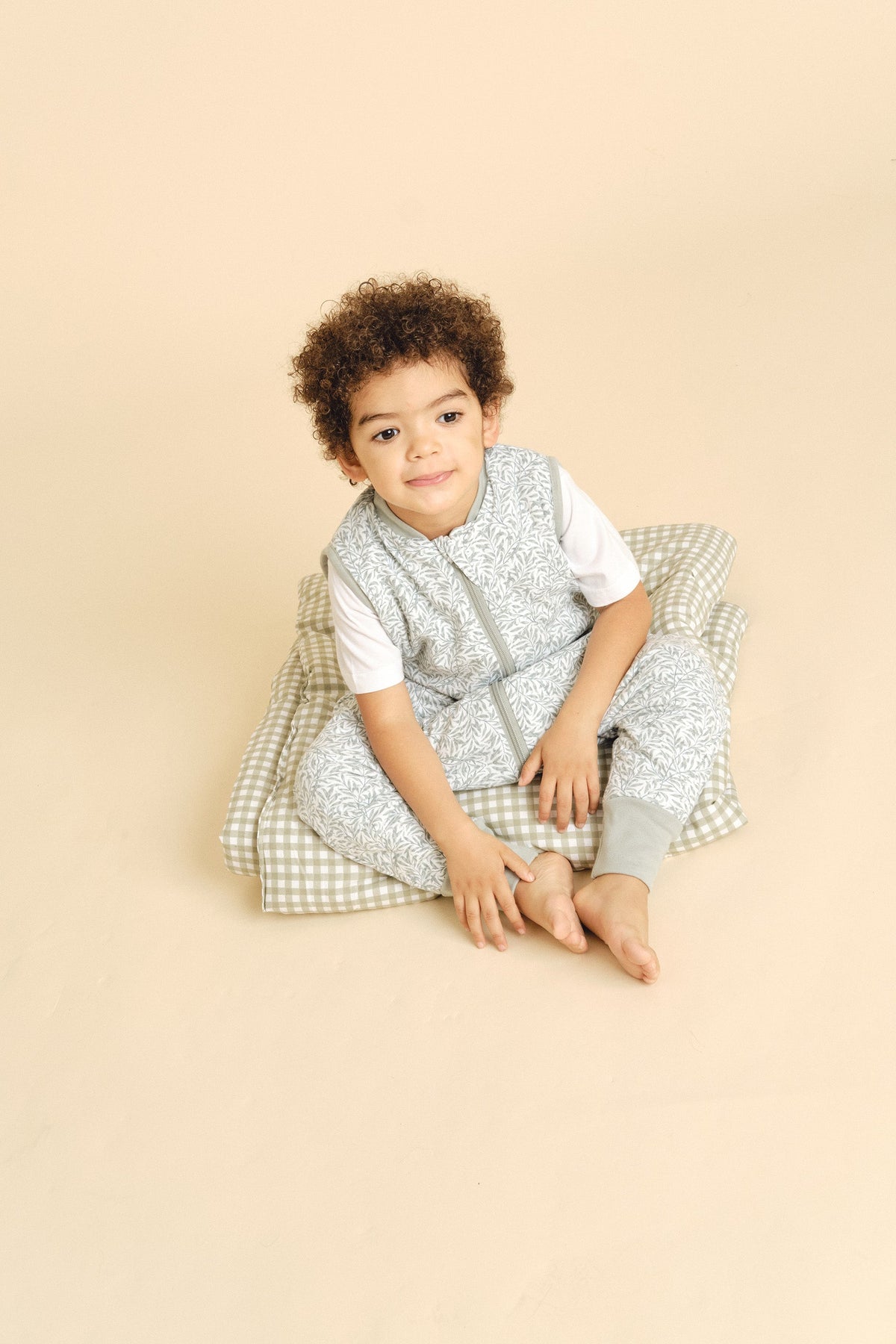 Criança vestida com o saco de dormir MolisandCo TOG 1.0 com pés no padrão Ines II