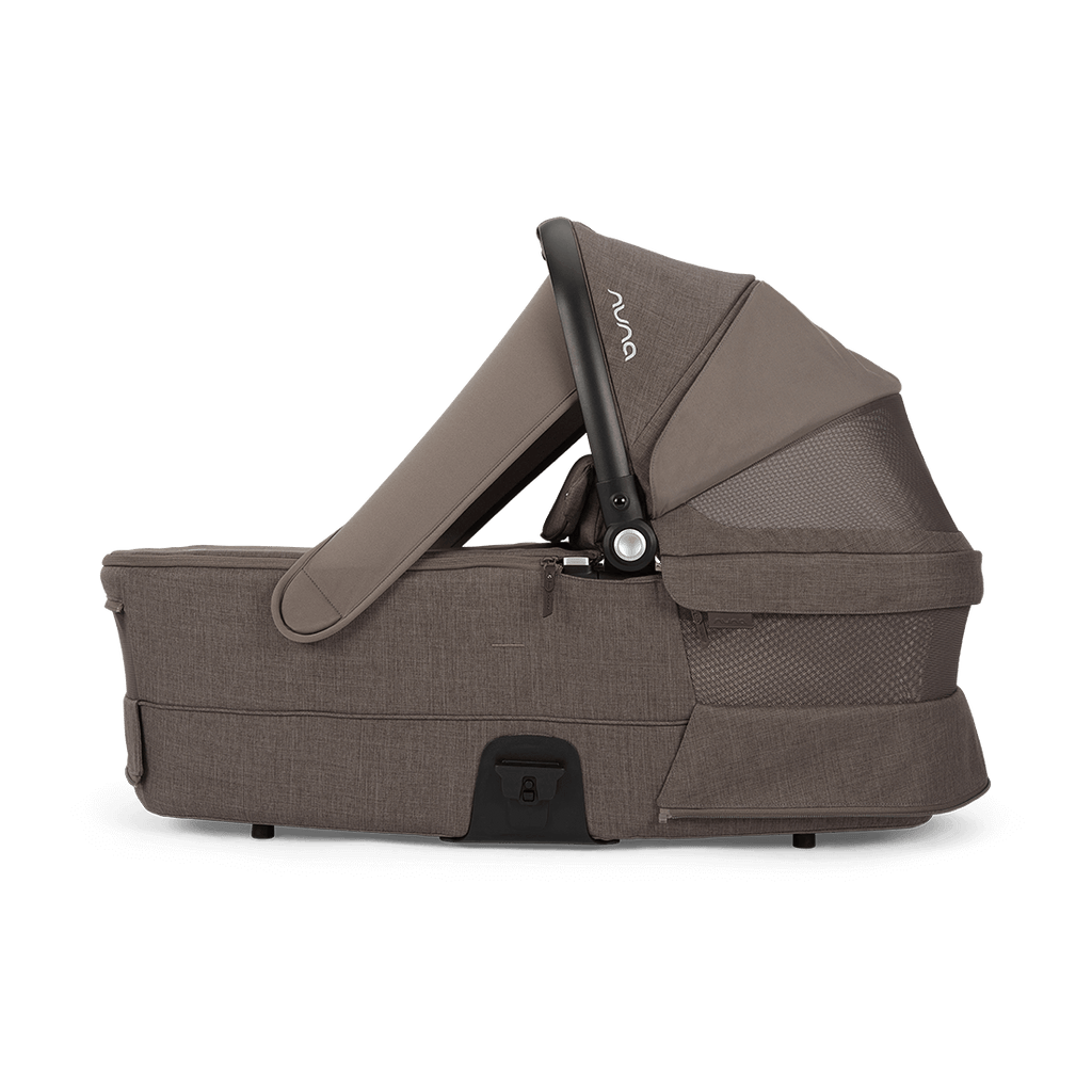 Alcofa Nuna MIXX next Chestnut de perfil com o Dream drape magnético descido para escurecer o interior.