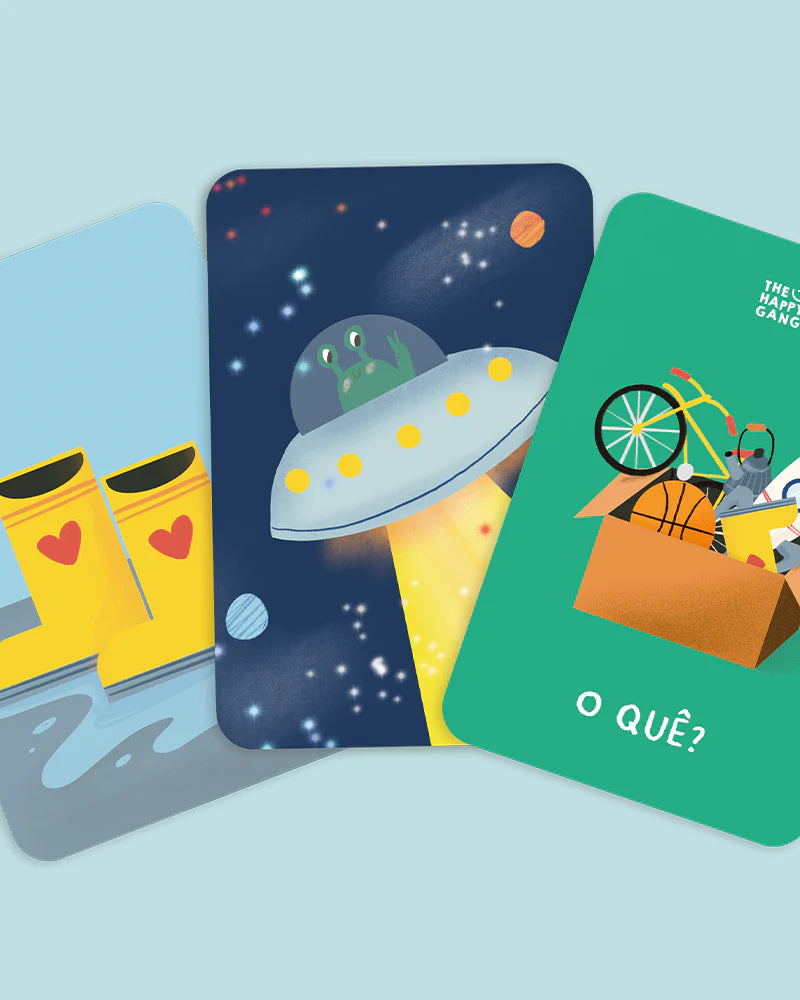 Três cartas ilustradas do jogo Telefone Estragado, mostrando imagens como galochas amarelas, um OVNI com um extraterrestre e uma caixa com brinquedos, com a palavra "O QUÊ?".