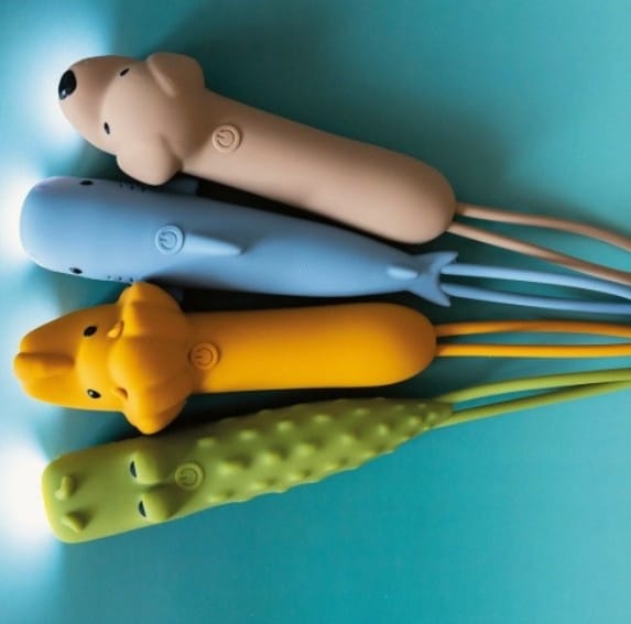 Quatro lanternas Rabbit e Friends de silicone acesas e alinhadas: um cão, uma baleia, o leão Leo e um crocodilo, em fundo azul.