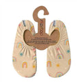 Par de meias antiderrapantes Slipstop modelo "Rainbow", em tom bege claro com estampado de arco-íris coloridos e pequenos sóis. Fabricadas com tecido respirável e de secagem rápida, possuem solas antiderrapantes para maior segurança em superfícies molhadas e secas. Ideais para piscina, praia, casa ou parques infantis.