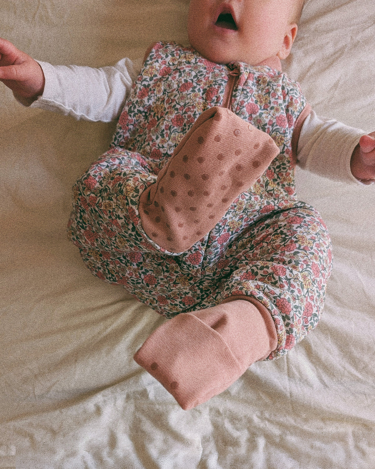 Pijama manta MolisandCo TOG 1.0 com pés e meias antiderrapantes na cor Peony, vestido por uma criança