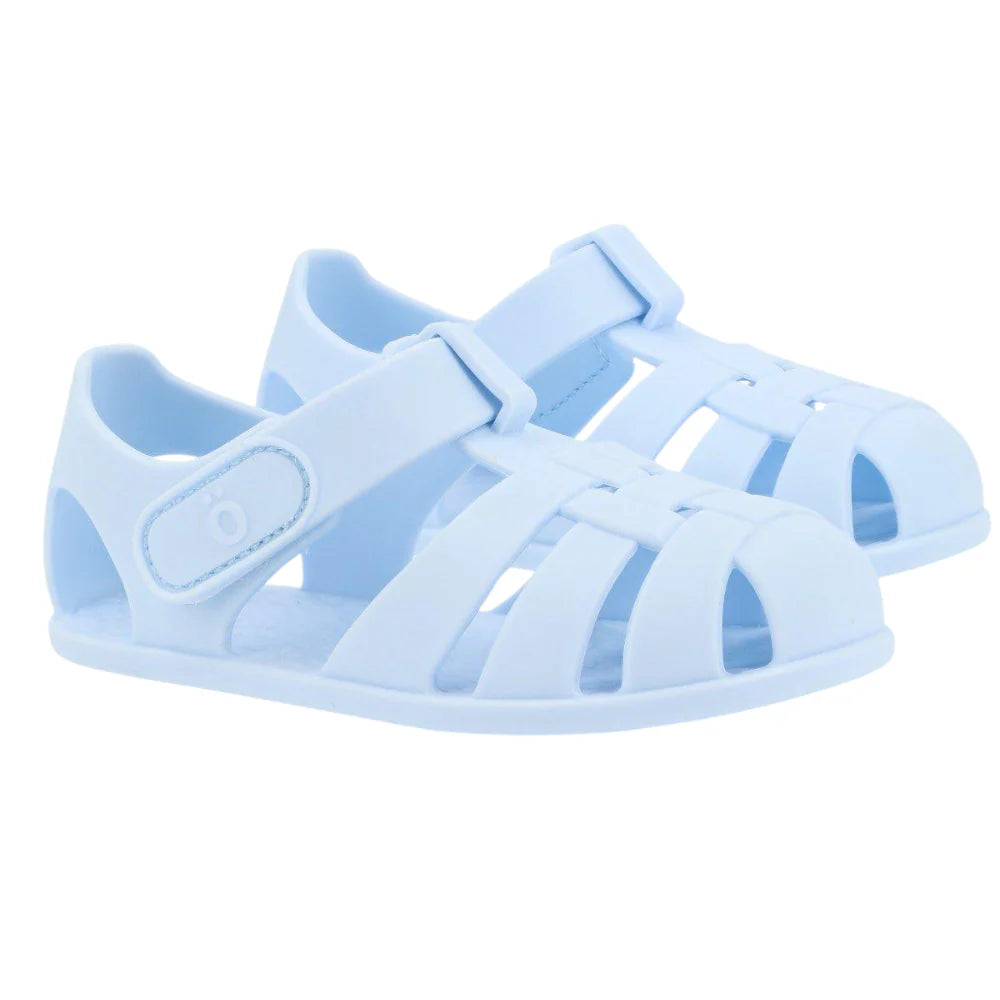 Par de sandálias Monneka azul claro, estilo barefoot, com fecho de velcro, vistas de lado num fundo branco.