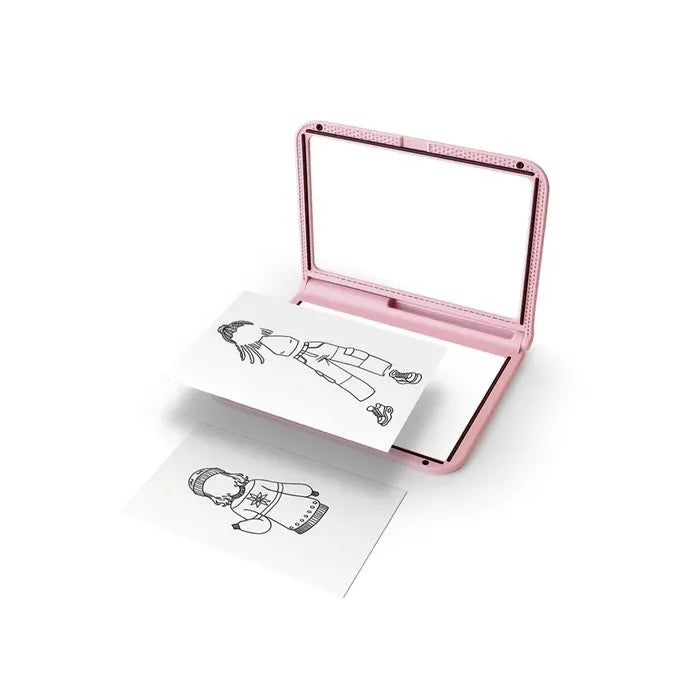 A prancha de desenho KidyDraw rosa aberta, mostrando a área de armazenamento de moldes de roupa e acessórios, com alguns moldes visíveis.