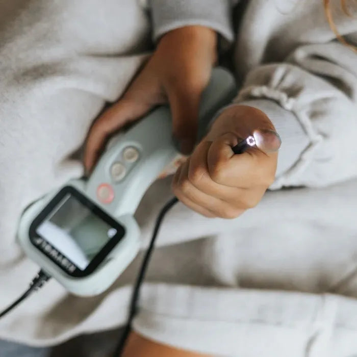 Criança a segurar o dispositivo KidyWolf KIDYEXPLORE, mostrando a ponta do cabo flexível com luz LED acesa.