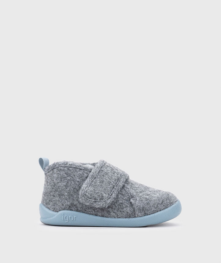 Uma pantufa barefoot Igor Homie em feltro cinzento com sola azul-oceano e fecho de velcro, vista lateral.
