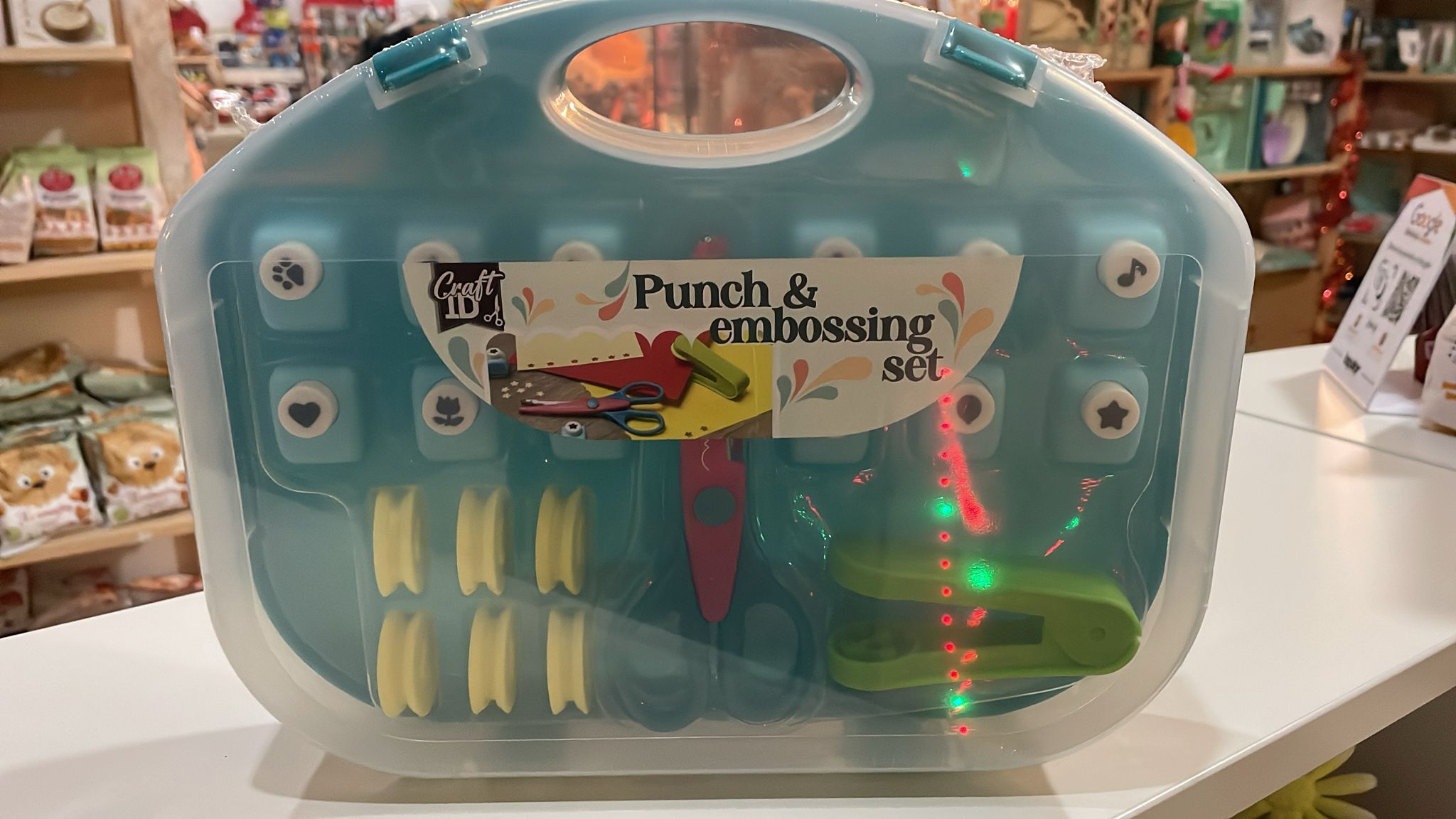 Kit estampagem e perfuração Craft ID com tesoura e perfuradores de formas, acondicionado em estojo de plástico turquesa.