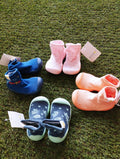 Conjunto de pantufas tipo meia em várias cores, incluindo azul, rosa e laranja, dispostas sobre relva artificial. Opções diversas para diferentes gostos e necessidades.
