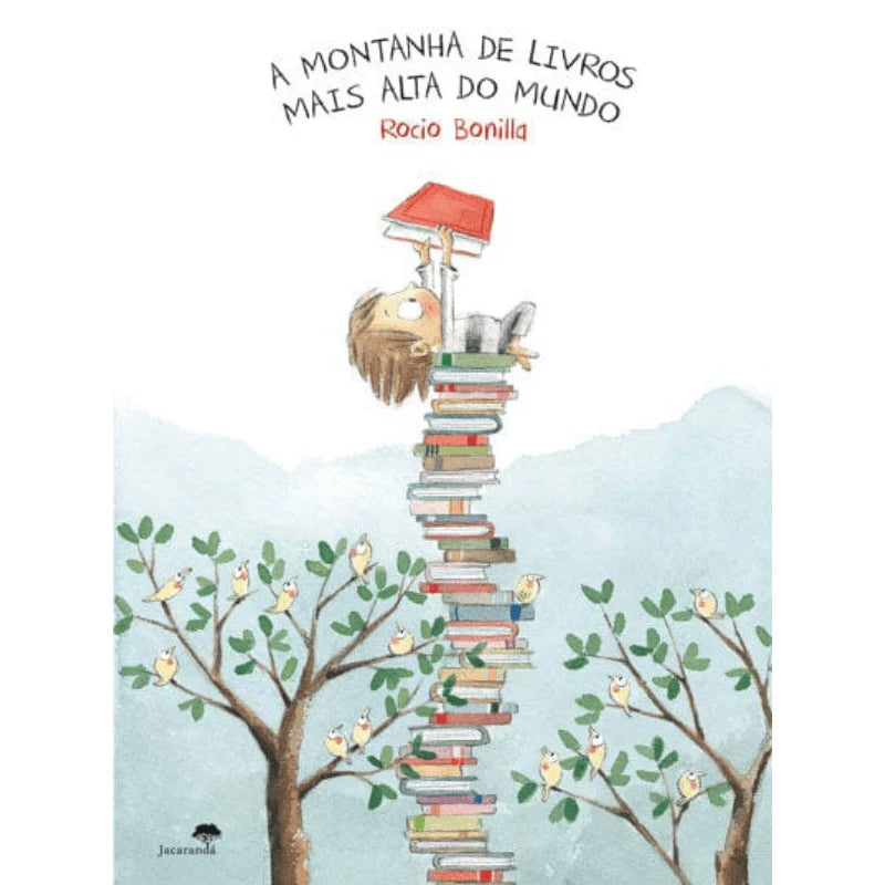 Capa do livro infantil "A Montanha de Livros Mais Alta do Mundo", com um rapaz a subir uma torre de livros, rodeado por árvores e pássaros.
