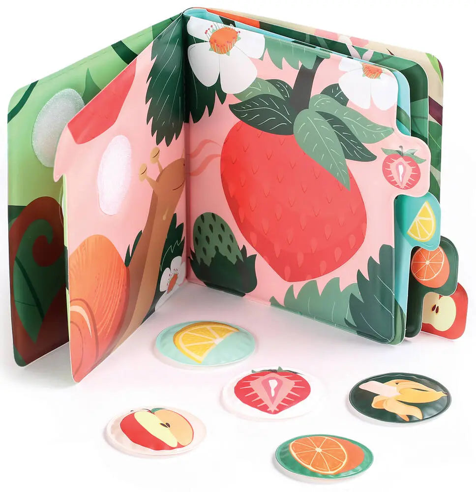 Livro de cheiros - Frutas da Ludi aberto, exibindo ilustrações de jardim e as cinco peças de frutas destacáveis para explorar os aromas.