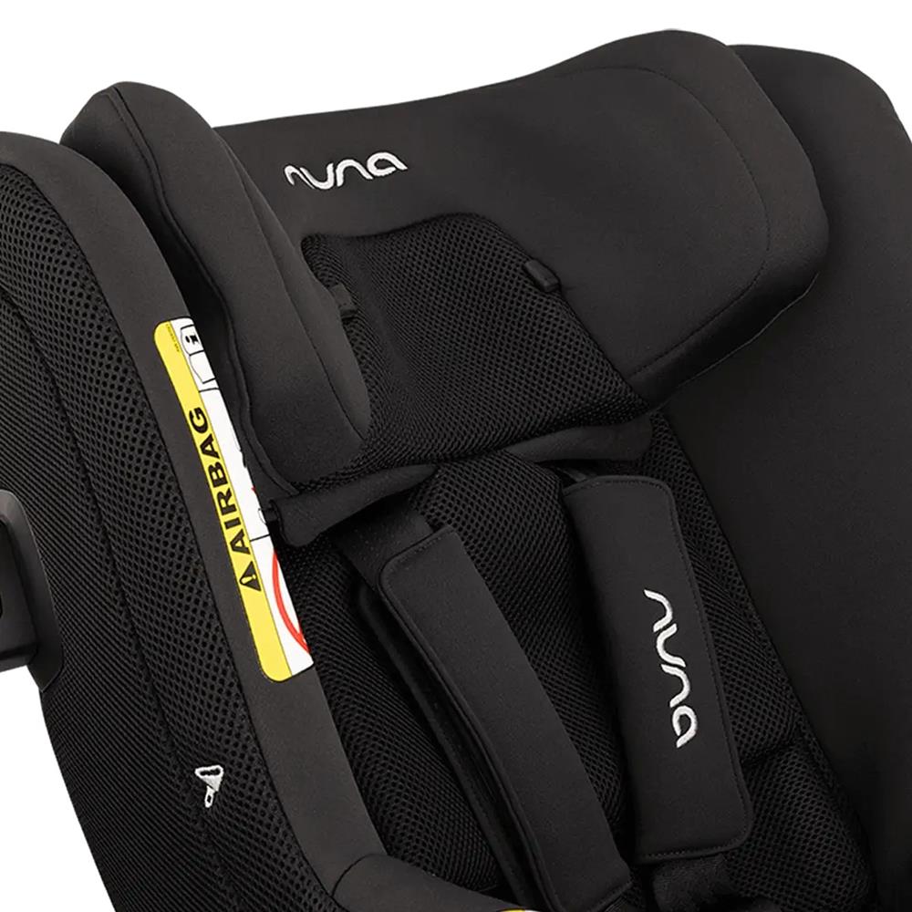Detalhe da forra de verão Nuna em tecido preto respirável, mostrando o logótipo Nuna e a área de encaixe dos cintos de segurança na cadeira auto.